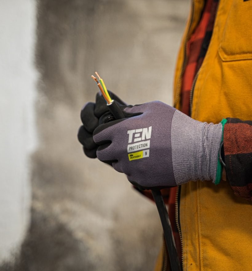 a person wearing gloves holding a pair of scissors